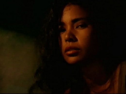 With a look reminiscent of the face on Johnny Mnemonic Disc 1 - 2, a person with long hair gazes neutrally at the camera under dim lighting, echoing classic vintage disc cover art.