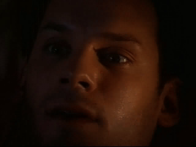 Close-up of a persons face in dim lighting, eyes widened and mouth slightly open, as if theyve just received an unexpected Johnny Mnemonic Disc 1 - 2 Microsoft Windows PC CD in a mysterious paper sleeve via USPS shipping.