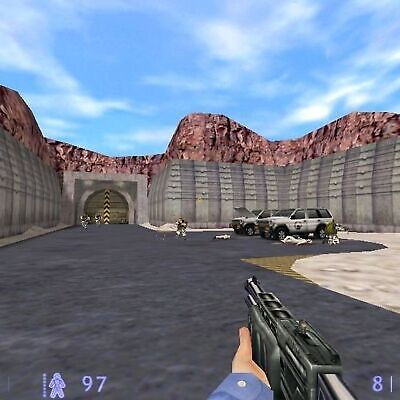 In the first-person view of Half-Life Blue Shift 2001 on my PC, I hold a weapon while the road winds through a mountain tunnel lined with vehicles and animated characters, reminiscent of an adventure once encased in its gently used CDs paper sleeve.