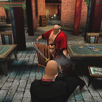 In a dimly-lit, Asian-themed room echoing *Hitman Codename 47*, a game character in black stealthily confronts others. One enemy wields a sword among tables with bowls, enhancing the tactical gaming vibe of the 2000 Microsoft Windows PC CD by Eidos and Io Interactive.