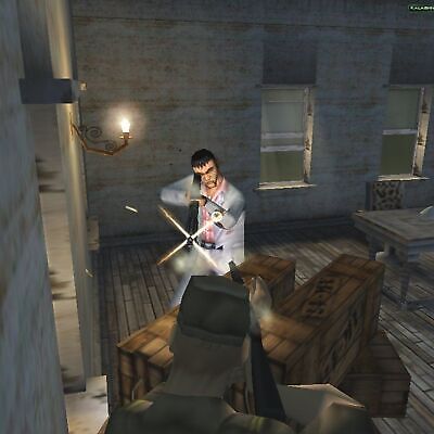 In a scene reminiscent of Hitman Codename 47 (2000, Microsoft Windows PC CD by Eidos Io Interactive), two characters occupy a dimly lit room. Tension mounts as the suited character skillfully fires at another hiding behind crates, embodying the essence of third-person shooter dynamics.